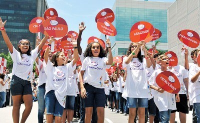 巴西小学生在仪式上手举印有火炬传递城市名称的牌子