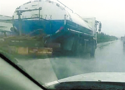  洒水车雨中洒水。网络截图