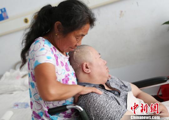 “好岳母”任增琴在为女婿高千军做肩部按摩。胡洪涛摄