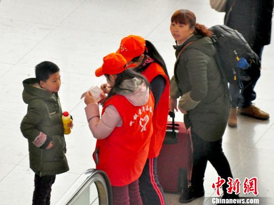 铁路青年志愿者为携带儿童出行的旅客提供咨询解答。吴正琪摄