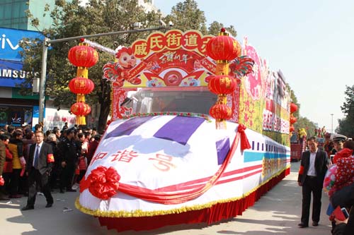 “和谐号”政策宣传车在人群的簇拥下驶向前方 王波 摄.JPG