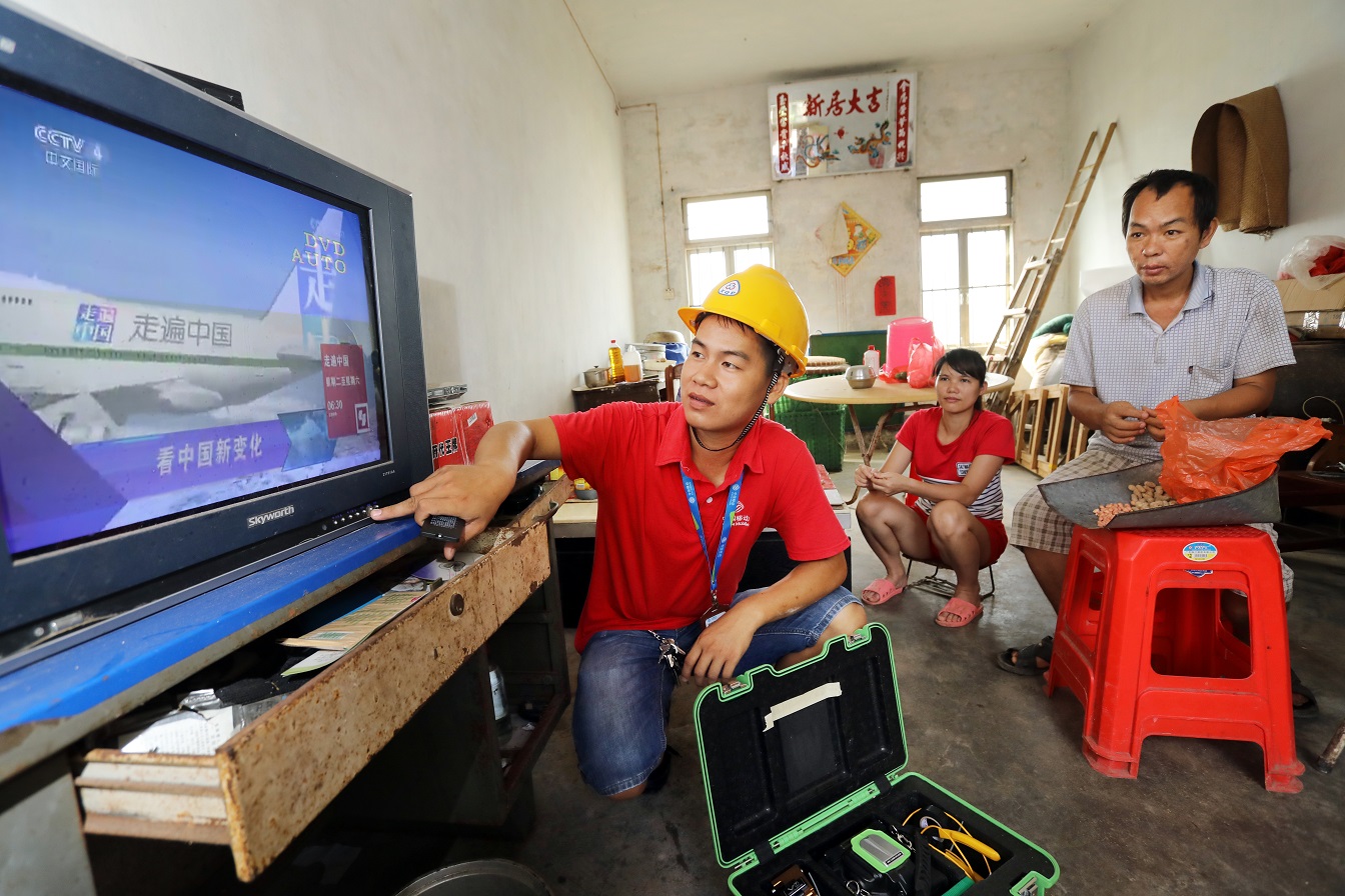 随着电信普遍服务工作推进，湛江市麻章区水塘村也实现了移动光纤覆盖。图为广东移动装维人员为村民安装宽带，调试电视.jpg