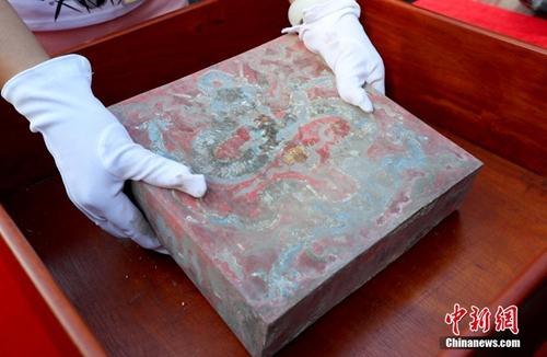 9月3日，故宫古建部副研究馆员徐超英展示养心殿正脊内的密封彩绘宝匣。中新社记者 张宇 摄