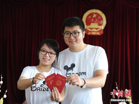 8月17日农历七月初七是我国传统“七夕节”，在吉林长春，许多准新人都选择这一天去办理结婚登记，有准新人在清晨5点就来到婚姻登记处排队等候。图为新人们展示自己的结婚证。 刘栋 摄