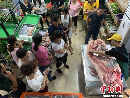 资料图:市民在海口市菜篮子销售点购买“放心猪肉”。王子谦 摄 资料图:市民在海口市菜篮子销售点购买“放心猪肉”。王子谦 摄