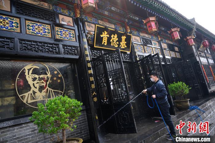 工作人员在古城里清洁店铺门面。韦亮 摄