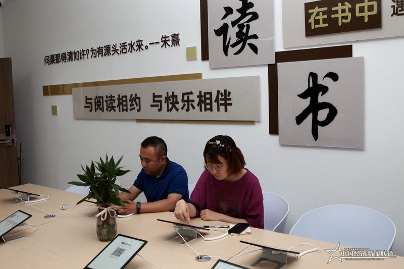 居民在凤山街道生态园社区歌德机上扫码读书 吴旭军摄.JPG