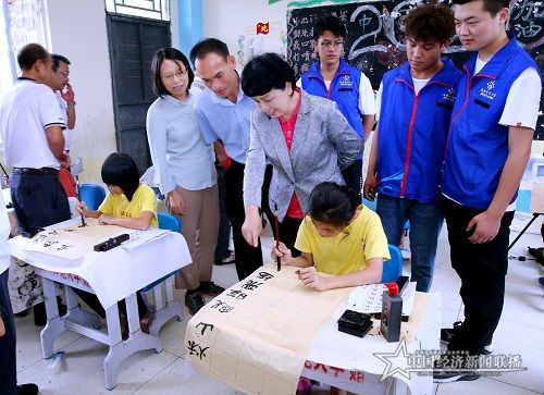 李红梅一行观摩亚欠村小学生练习书法.jpg