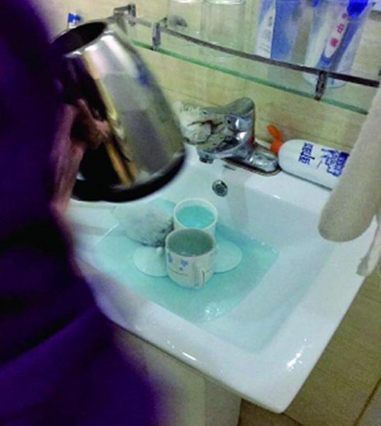 图说:酒店服务员用洁厕液刷烧水壶和茶杯。来源:北京晨报