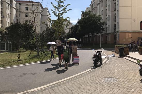 家长帮孩子把快递背到寝室。